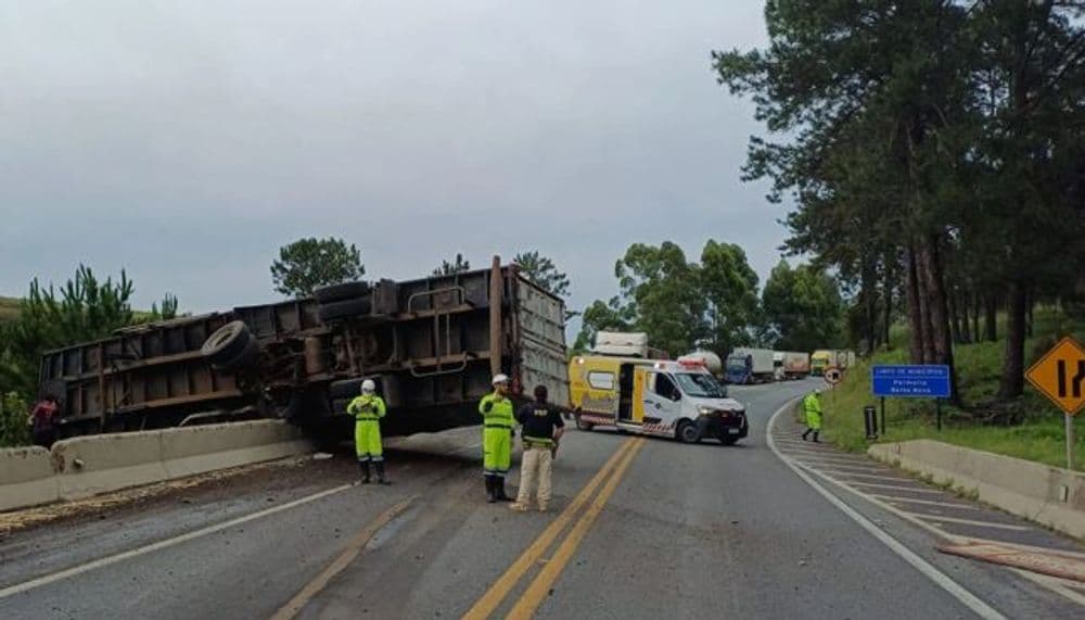 Caminhão bitrem tomba, semirreboque fica pendurado em ponte na BR-277 e interdita pista entre Palmeira e Balsa Nova